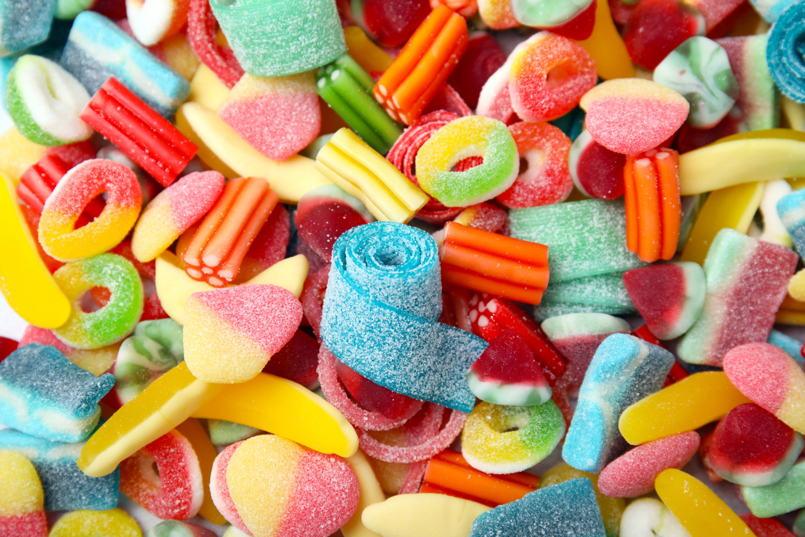 Tasty colorful jelly candies as background, above view